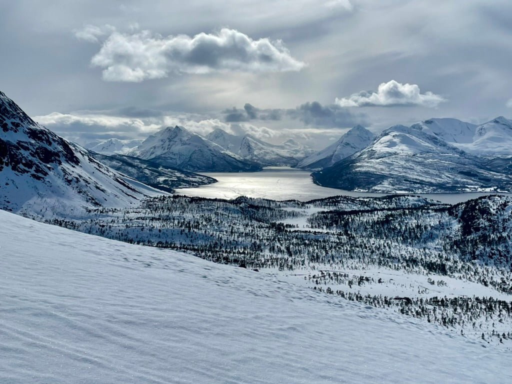 Southern Ullsfjorden with sunlight reflecting through clouds and snowy mountains