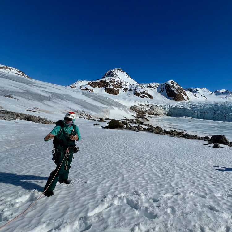 a ski guide gives a glacier travel briefing before ascending a tidewater glacier in kulusuk east greenland with the carving face above a frozen fjord
