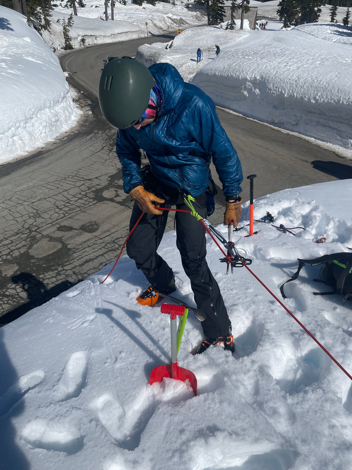 During Crevasse Rescue practice, a student uses an extended rappel and gets ready to  lower themselves over the edge of a road cut.  