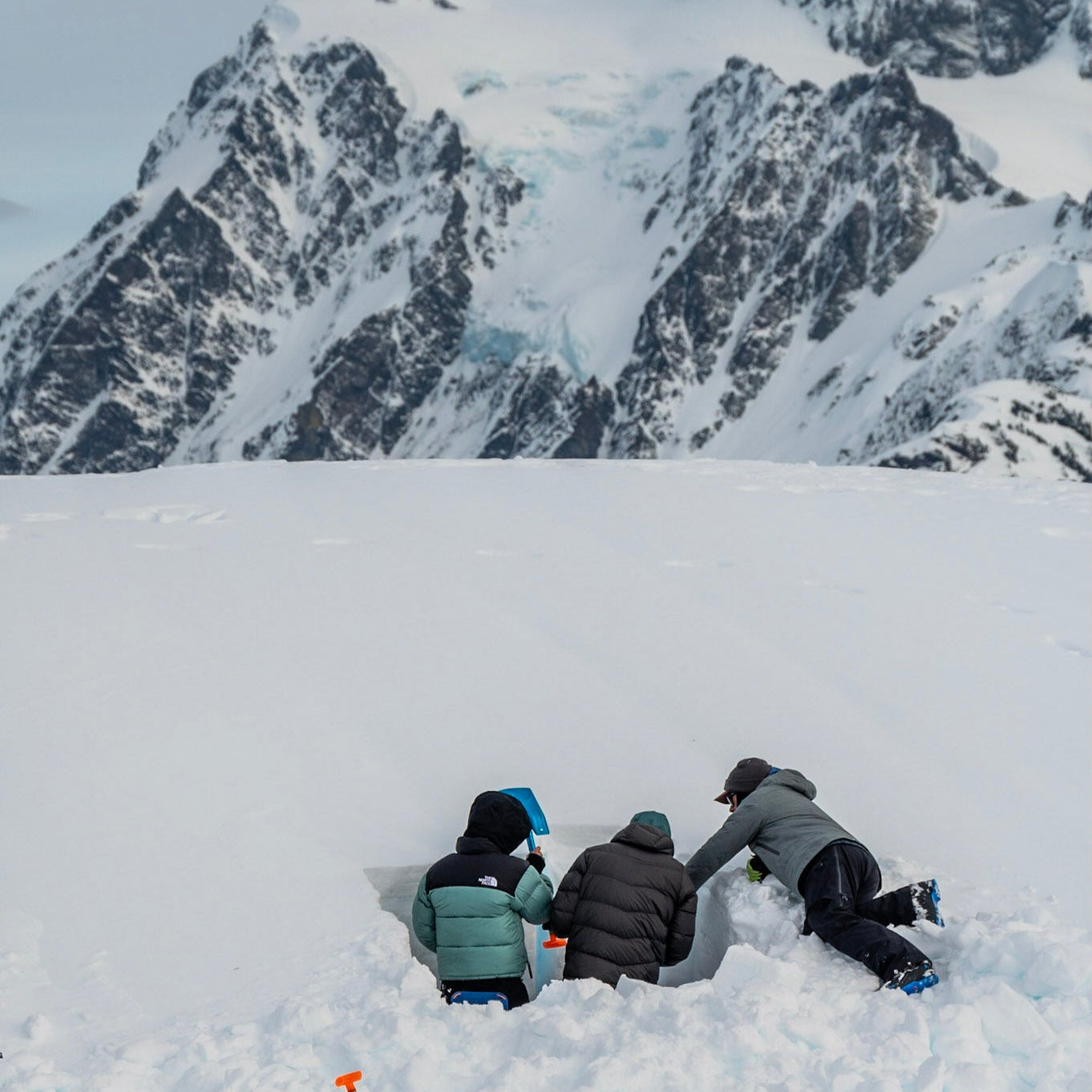 AIARE 1 students get feedback on their snow profile from the Lead Guide at Guided Exposure. Mount Shuksan stand tall in the background on a stunning day in the Mount Baker Backcountry.