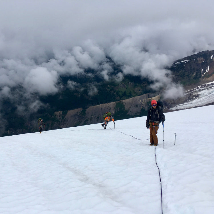 Our guides lead a rope team above the clouds on the Coleman Glacier.