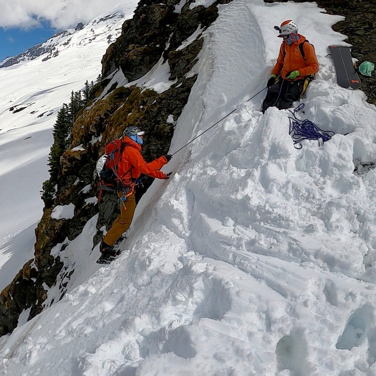 Lead guide and Founder of Guided Exposure belaying a guest into a steep couloir.