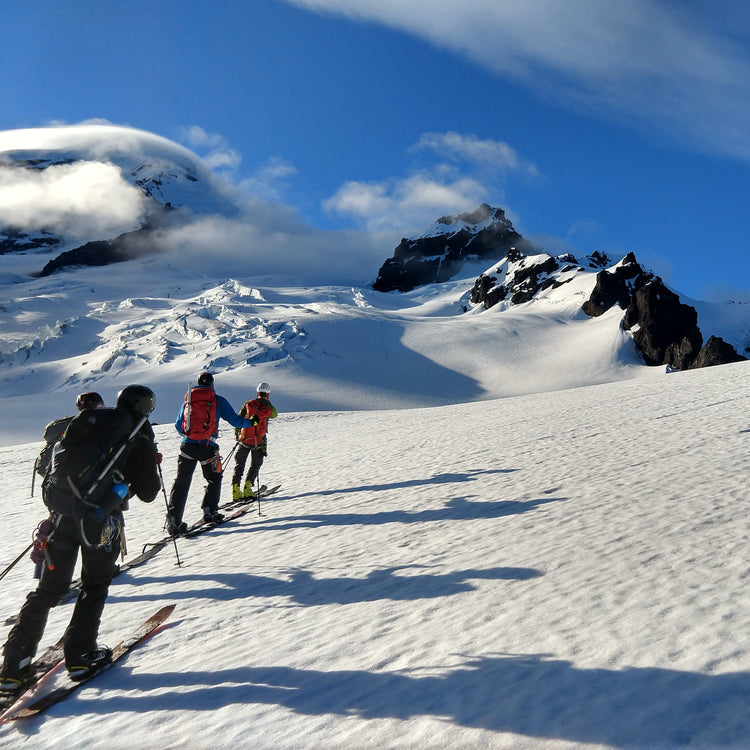 Splitboarder Mountaineers on Mount Baker making their way up through glaciated terrain towards the summit.