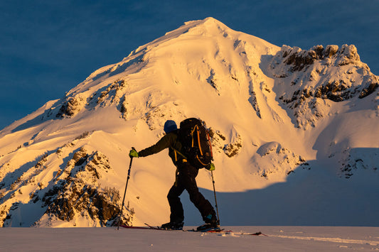 A splitboard moutaineer carries a daypack while enroute to a mountaineering objective