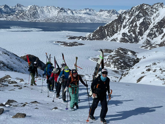 Group of skier hike above frozen fjords and snowy mountains in the north atlantic