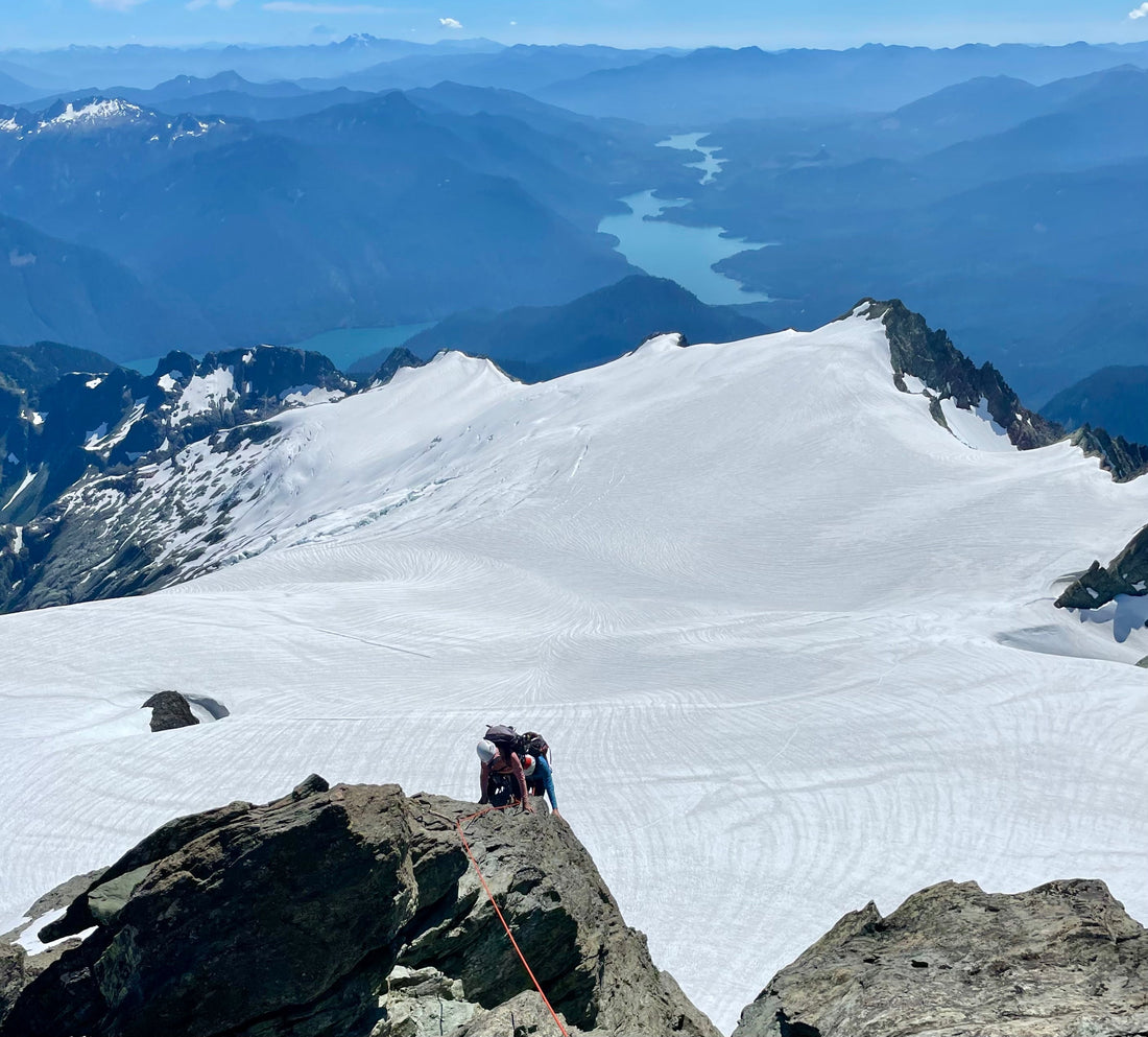 A mountaineer climbs the south east ridge on mount shuksan with the sulphide glacier and baker lake below