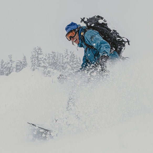 Person snowbaoridng in deep snow with a backpack