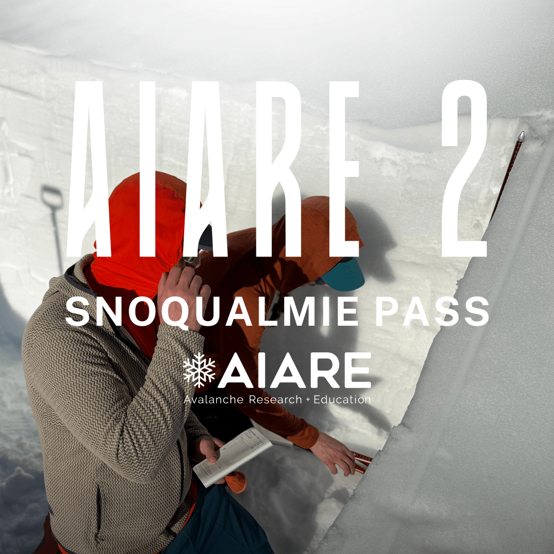 Person in winter gear examining snow with AIARE 2 Snoqualmie Pass