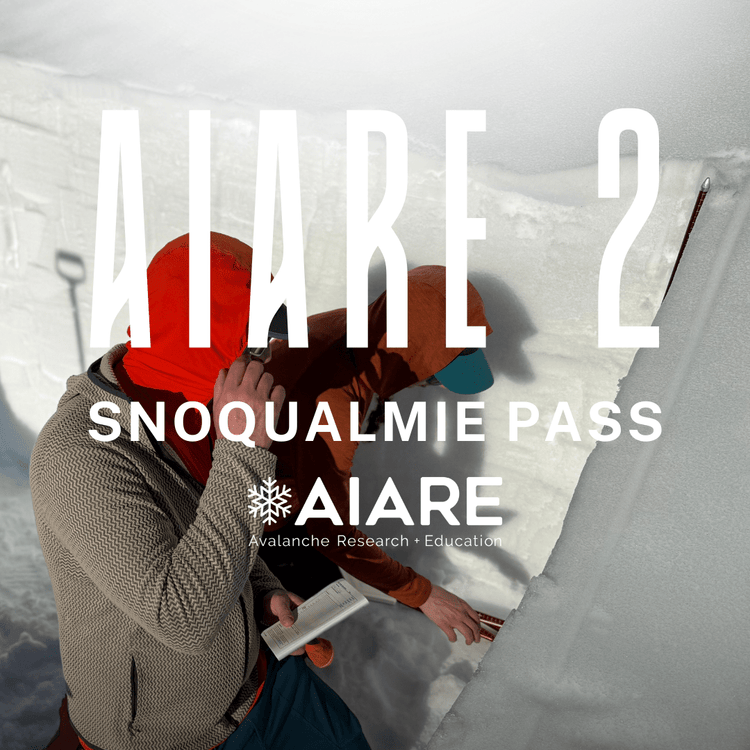 Person in winter gear examining snow with AIARE 2 Snoqualmie Pass