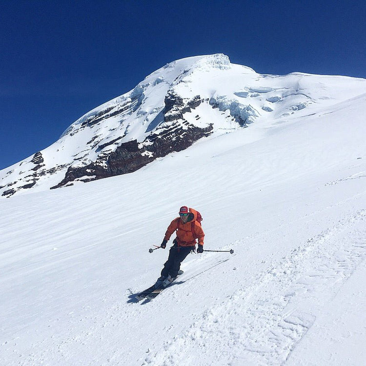 Skier coming off of mount baker on a crystal clear day. 
