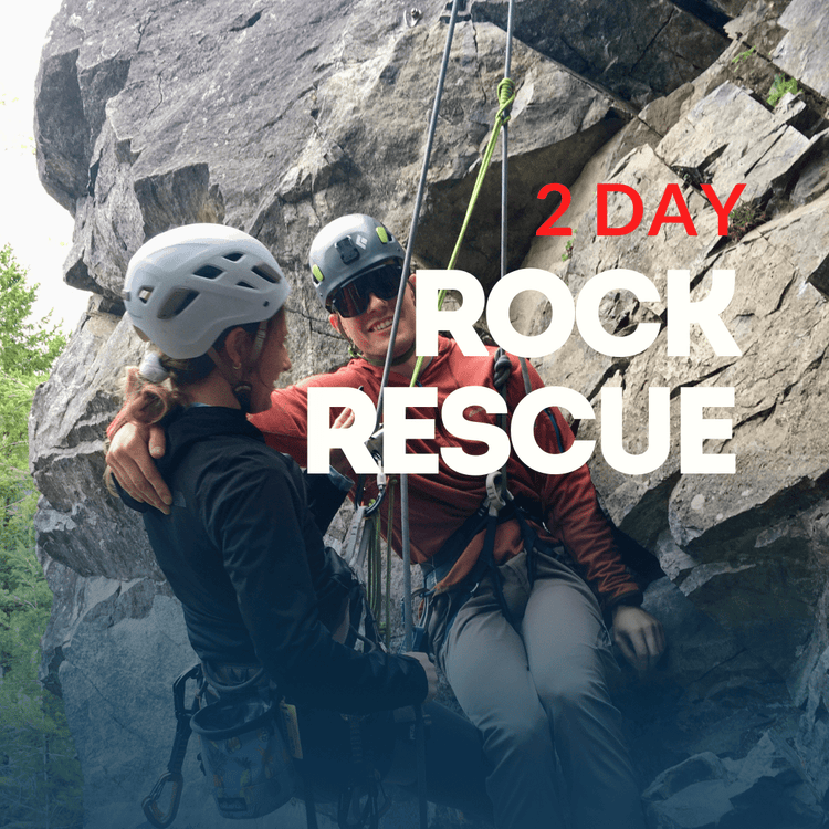 Two climbers on a rocky cliff with safety gear, surrounded by water.