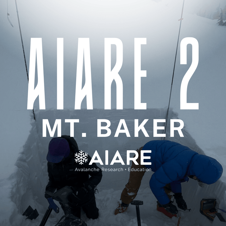 Two mountaineers on a snowy mountain peak with Mt. Baker - Watson Traverse