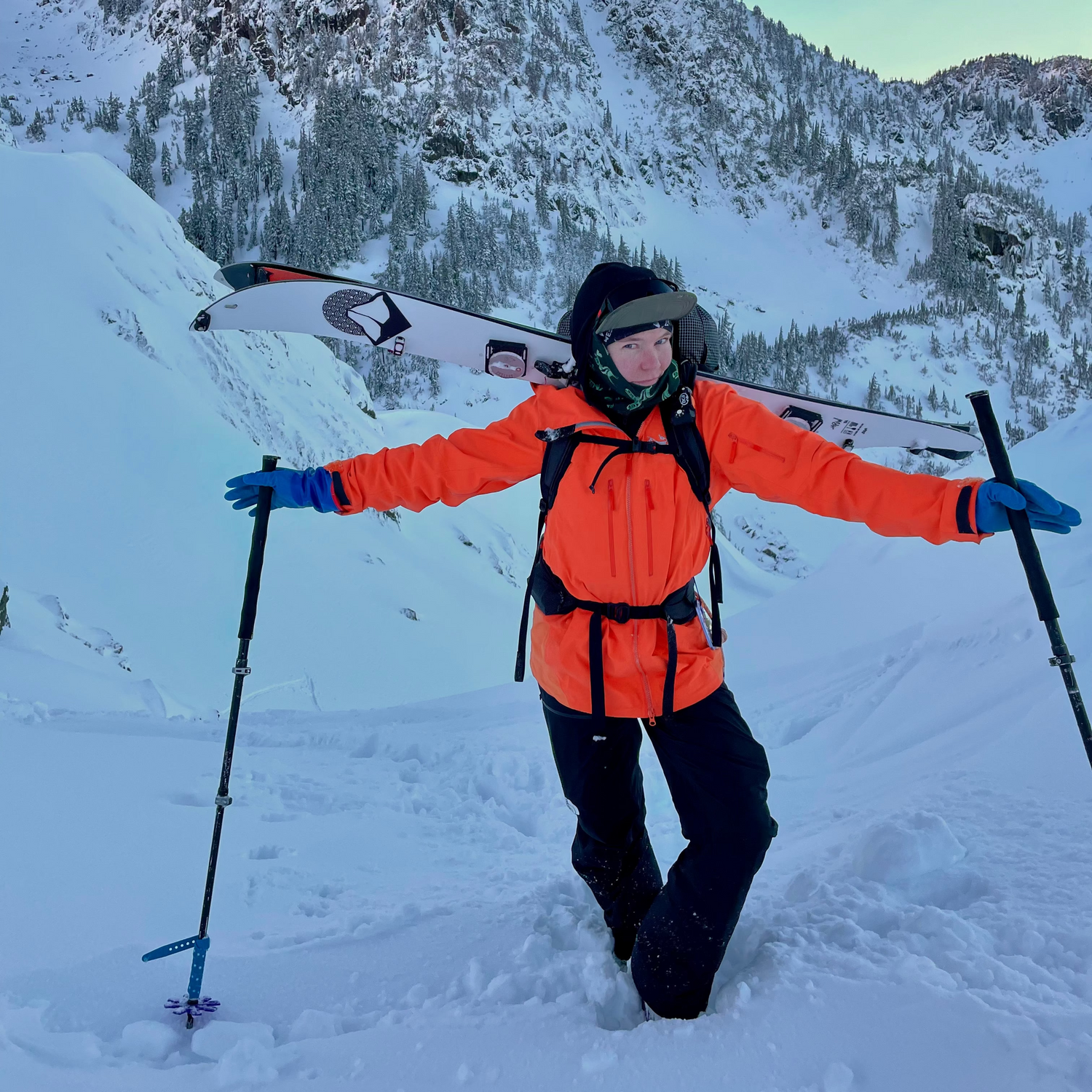 Women Ski Guide in an orange jacket with skis on a snowy mountain at mt baker ski area