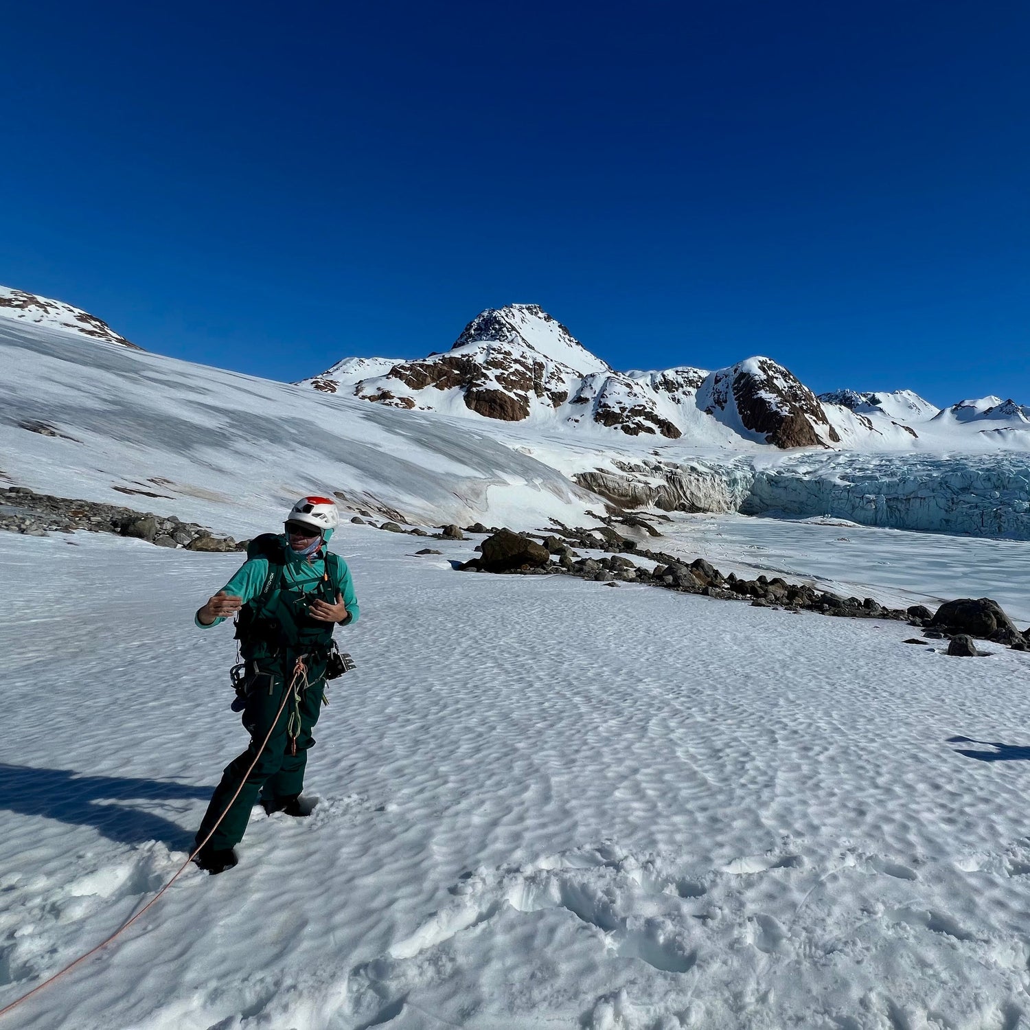 a ski guide gives a glacier travel briefing before ascending a tidewater glacier in kulusuk east greenland with the carving face above a frozen fjord