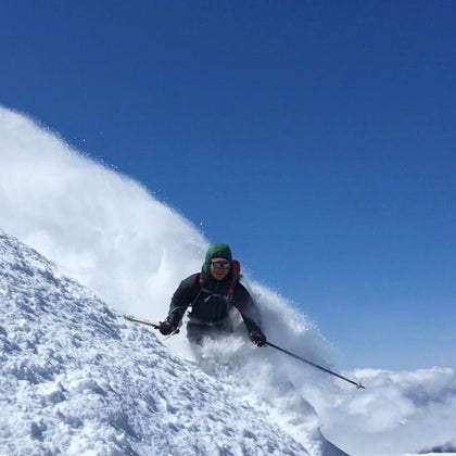Advanced Skiing down a steep snowy face with a blue ski background. During and advanced ski touring course on mount shuksan