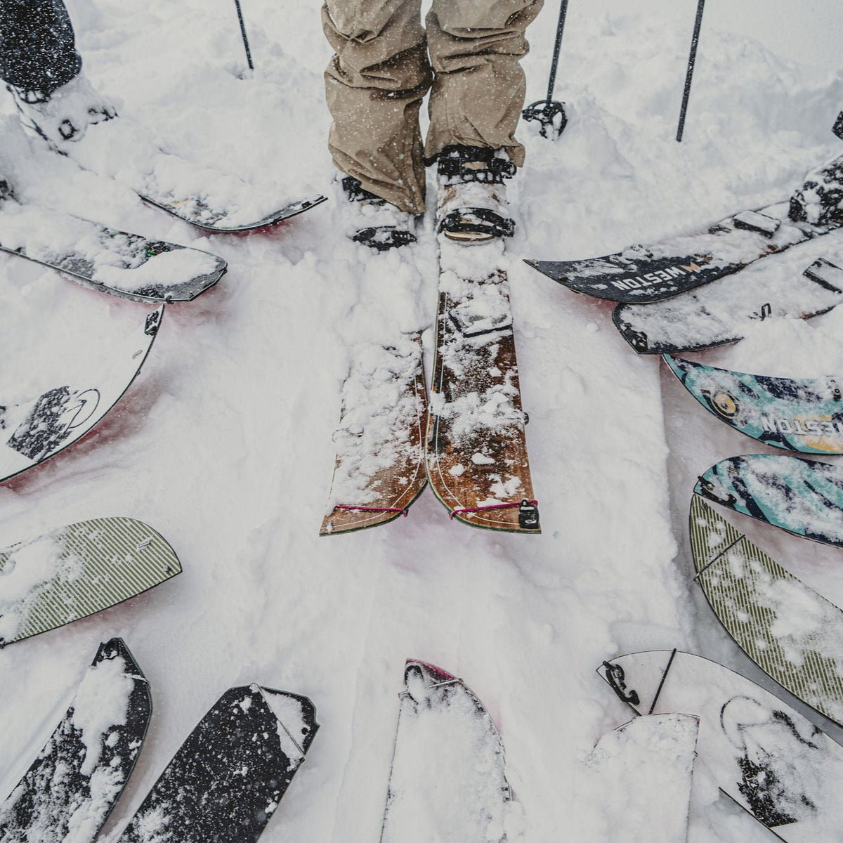 Splitboards arranged in the snow around a rider's boots during a women's splitboarding progression series at Mount Baker