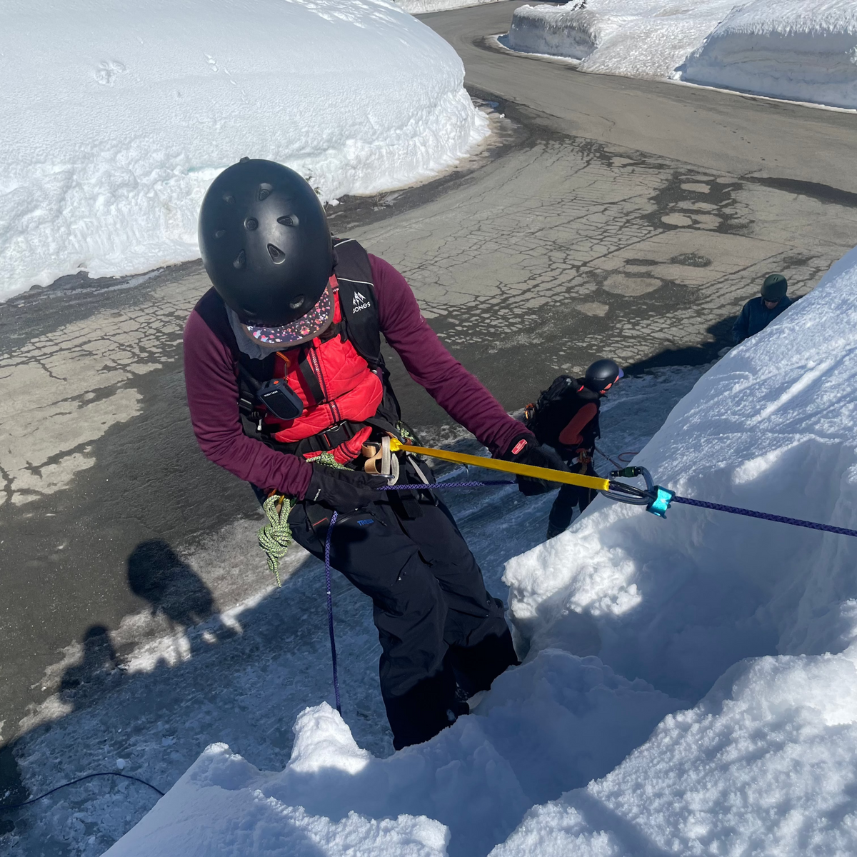 Student rappels over a road cut while practicing crevasse rescue. 