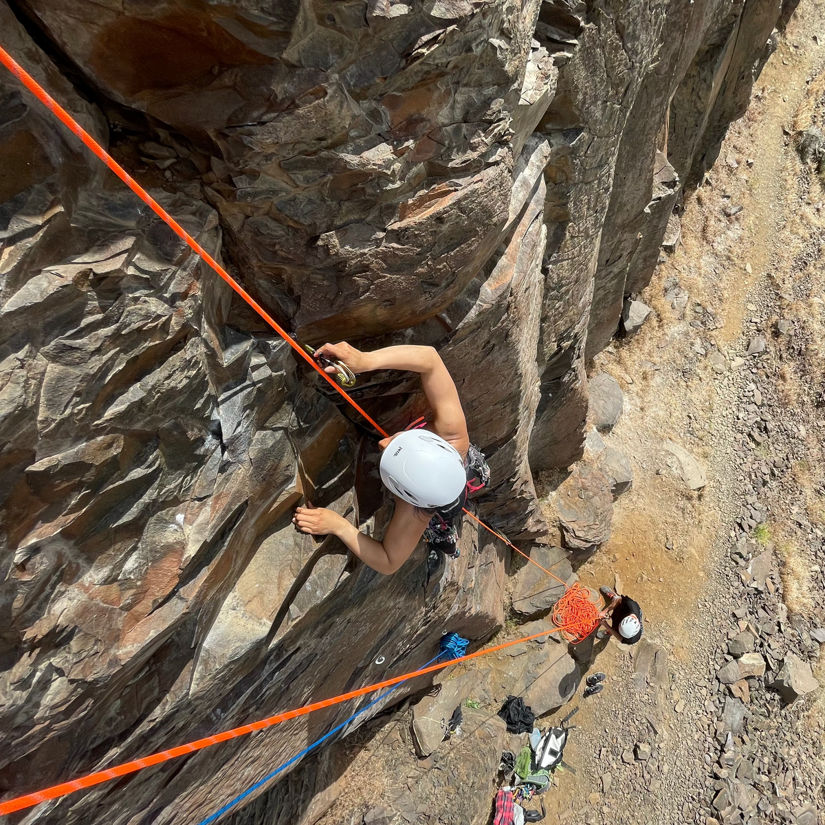 A climber practicing placing traditional rock protection in a crack on a climb. 