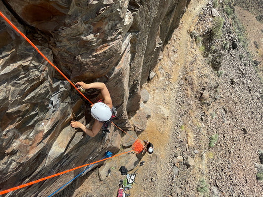 A climber practicing placing traditional rock protection in a crack on a climb. 