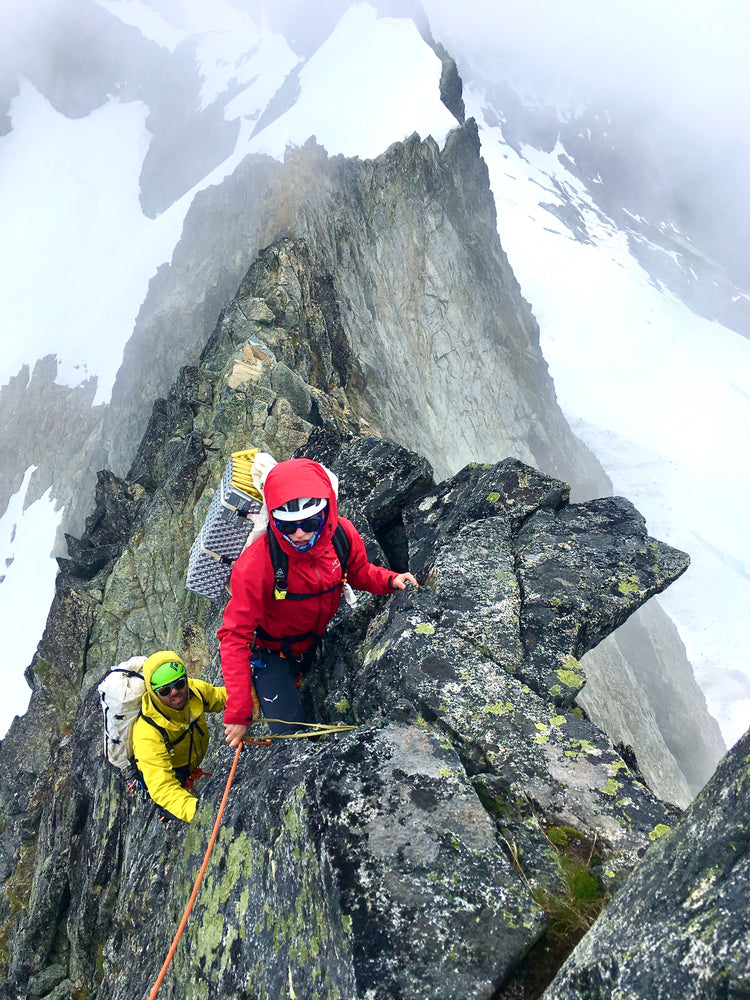 2 climbers have beautiful exposure on the lichen covered North Ridge of Forbidden Peak