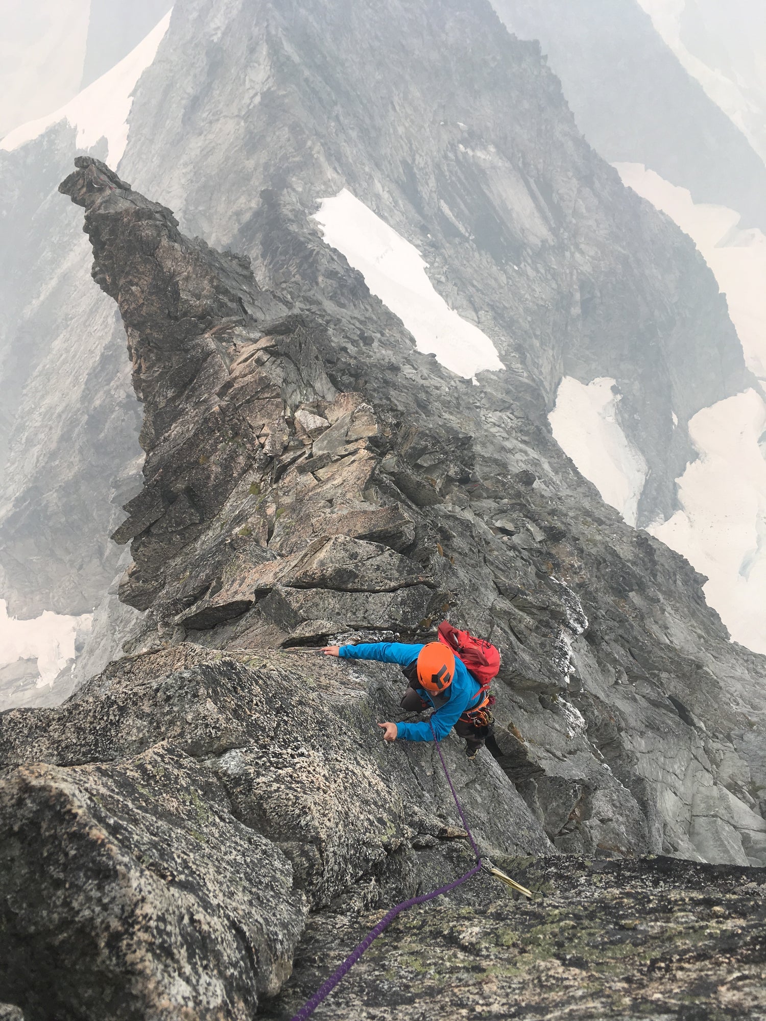 a climber high on the west ridge of forbidden peak