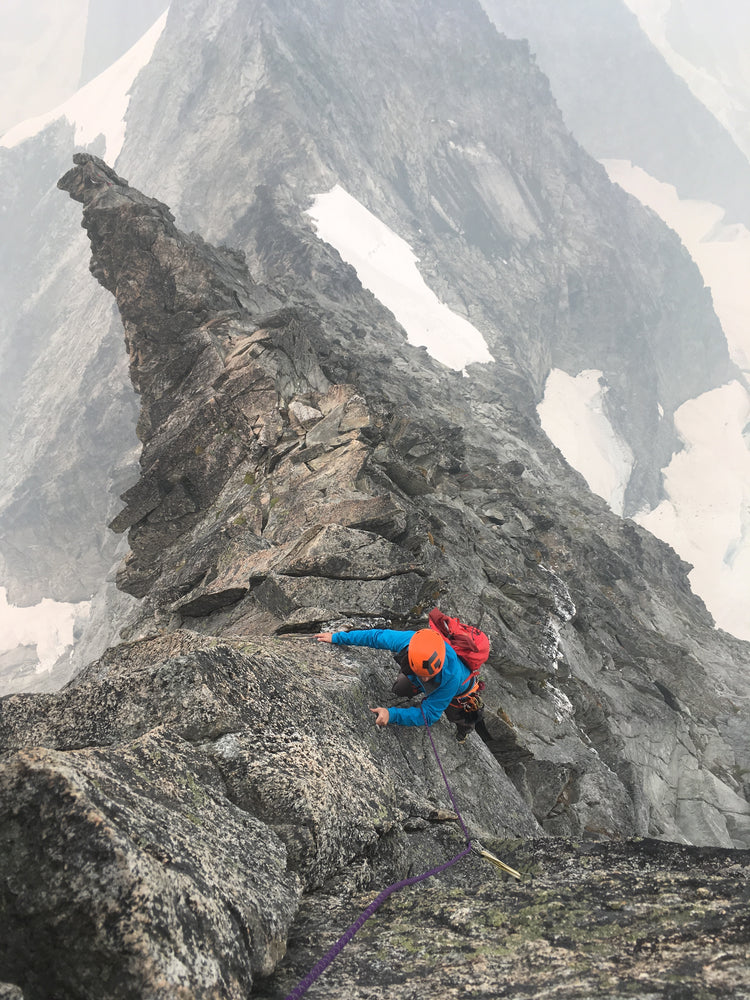 a climber high on the west ridge of forbidden peak