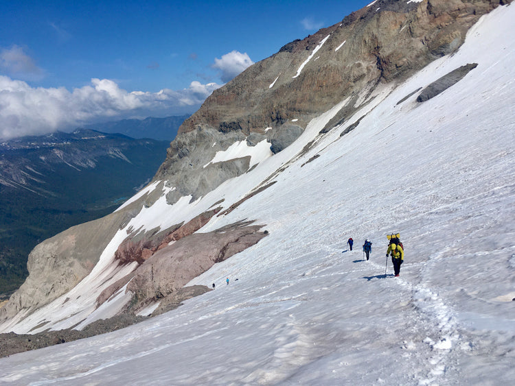 blue skies and clouds over over climbers on the interglacier