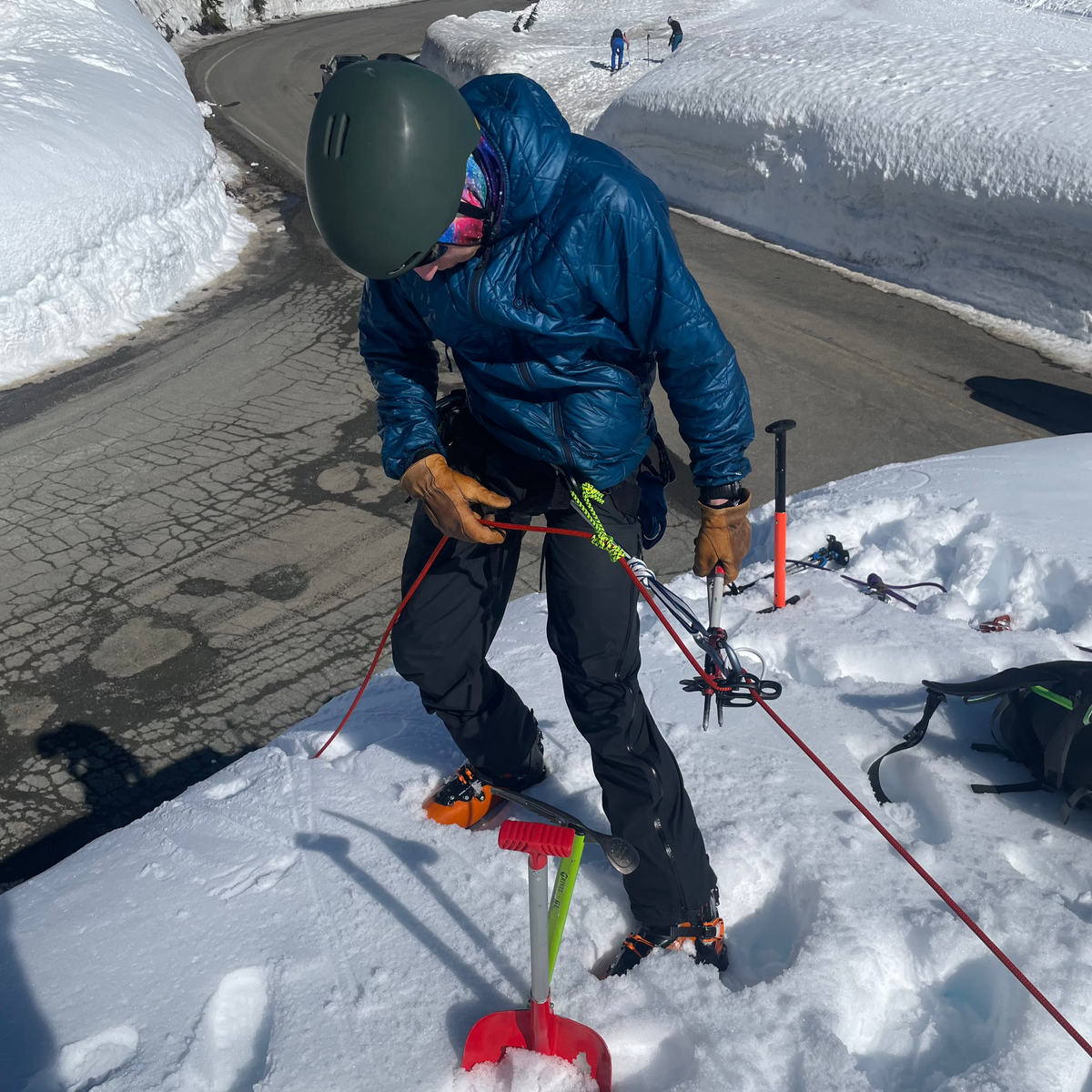 During Crevasse Rescue practice, a student uses an extended rappel and gets ready to  lower themselves over the edge of a road cut.  