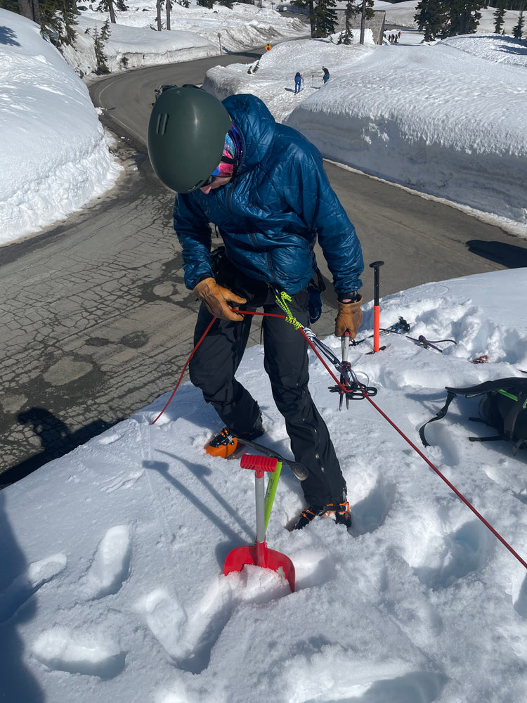 During Crevasse Rescue practice, a student uses an extended rappel and gets ready to  lower themselves over the edge of a road cut.  