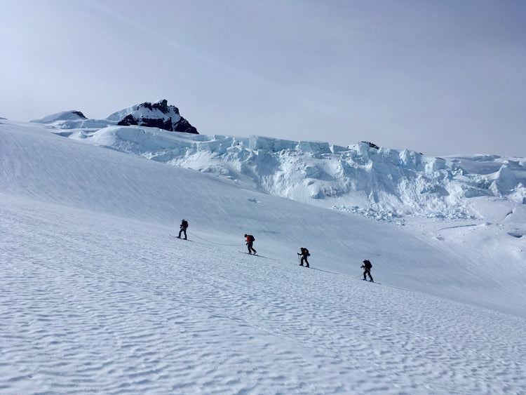 On the ski mountaineering course the group of four move through glaciated terrain on a rope.