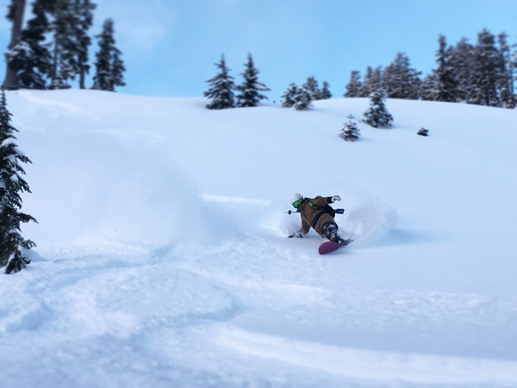 Splitboarder turning in deep snow as they ski through their powder cloud. 