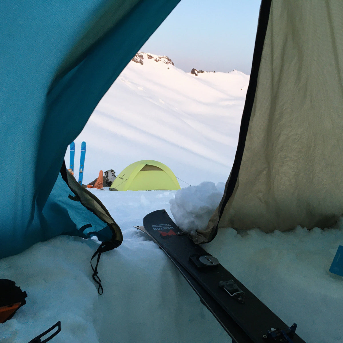 Tent interior with skis and snow-covered mazama glacier landscape outside