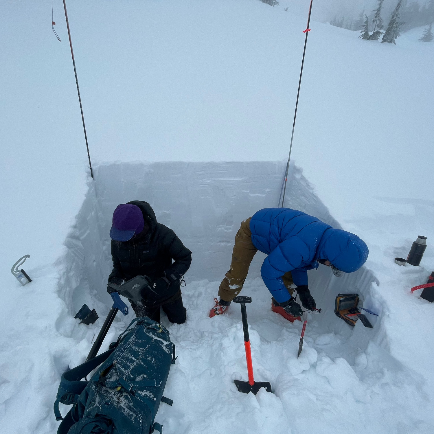 Two AIARE 2 students in their snow pit recording observations and findings at snoqualmie pass