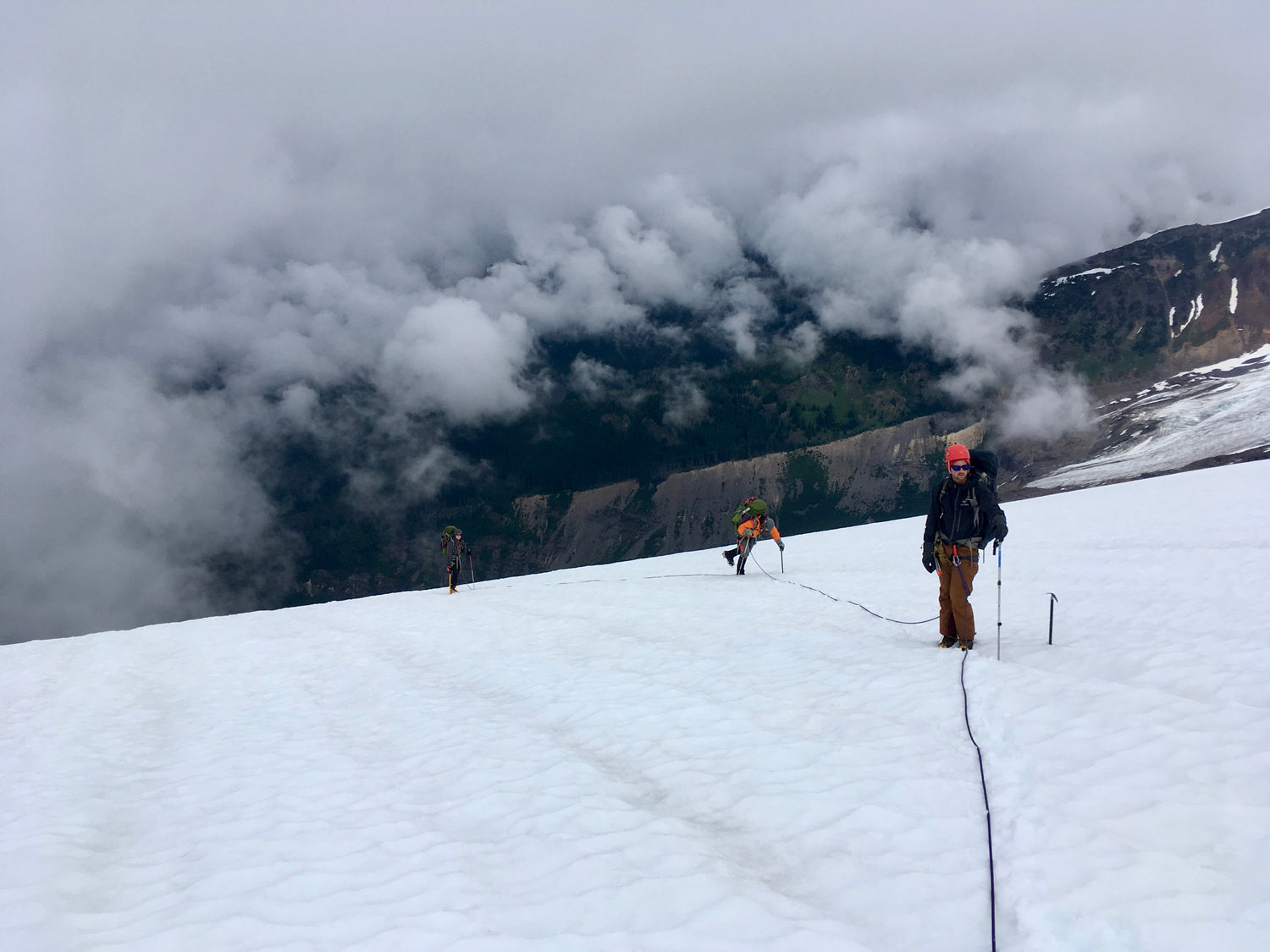 Our guides lead a rope team above the clouds on the Coleman Glacier.