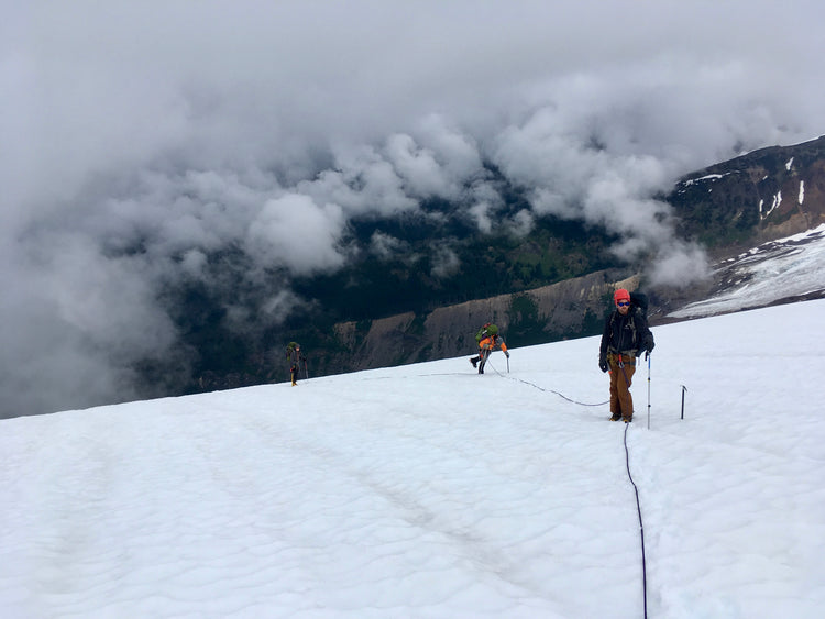Our guides lead a rope team above the clouds on the Coleman Glacier.