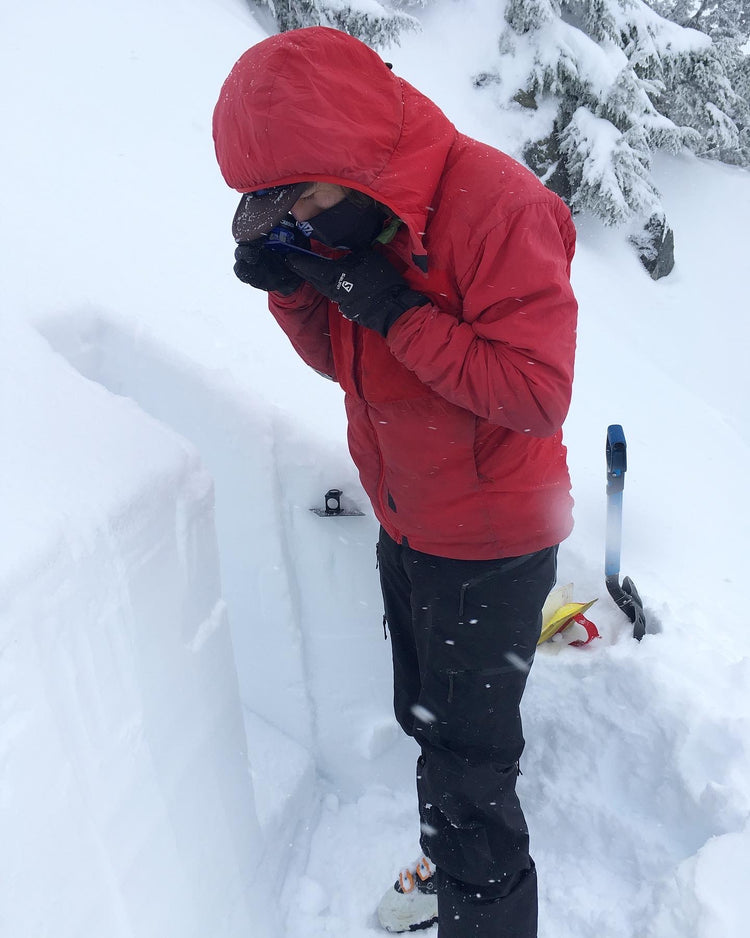 Looking at snow crystals with a loupe to see the shape and size of the snow. Identifying layers in the snowpack during an AIARE 2 course in the Mount Baker backcountry. 