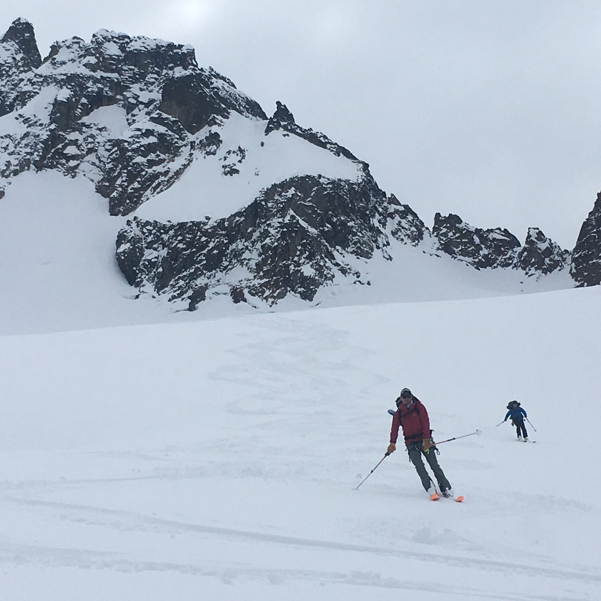 2 skiers follow their amga ski guide on the Boston Glacier. making turns on soft snow with in North Cascades National Park during the Forbidden Tour
