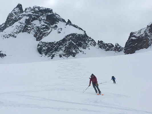 2 skiers follow their ski guide on the Boston Glacier. 