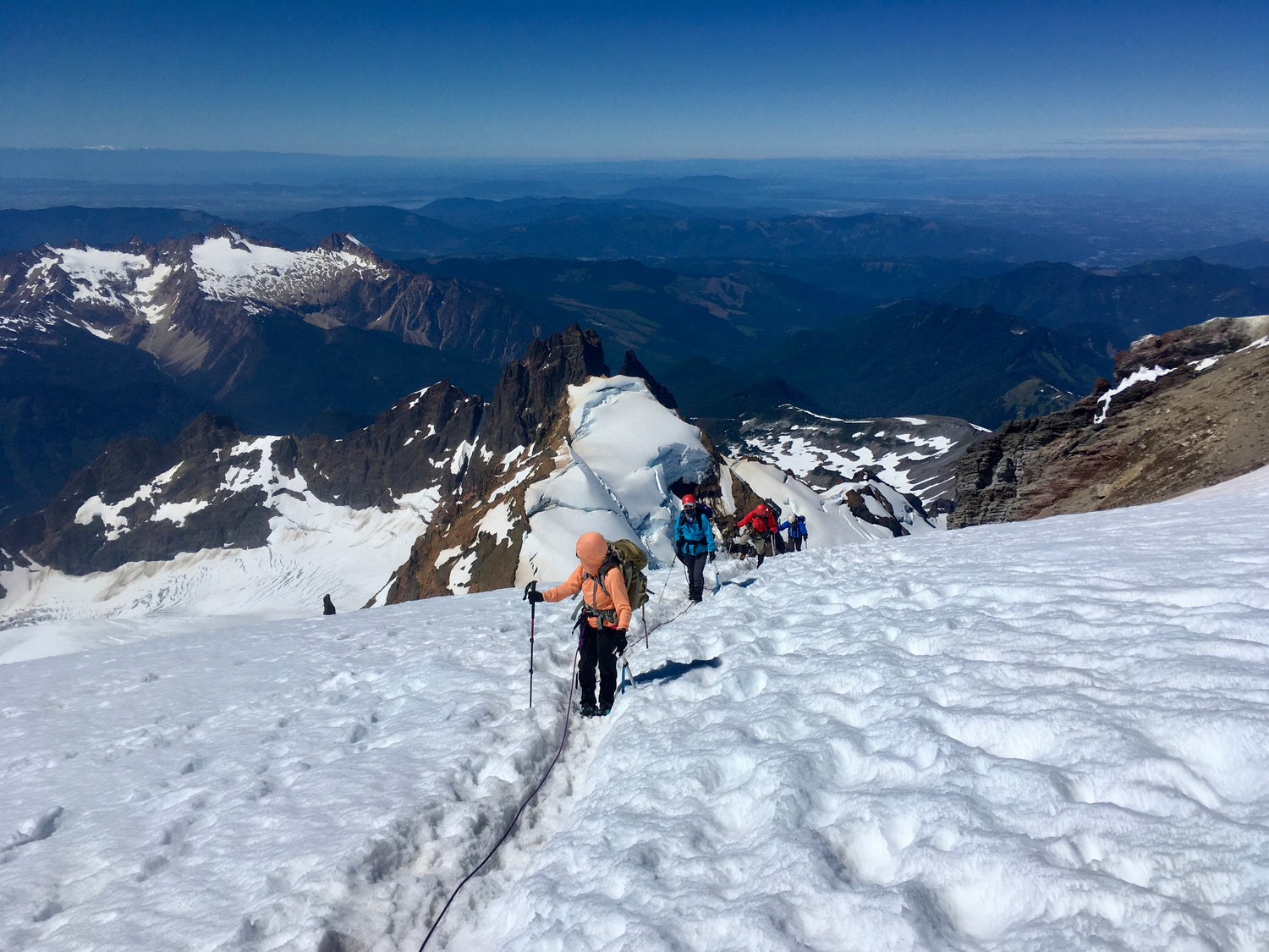 A guided trip nears the summit of Mount Baker while views of Colfax, the Twin Sisters, and the Puget Sound are below. 