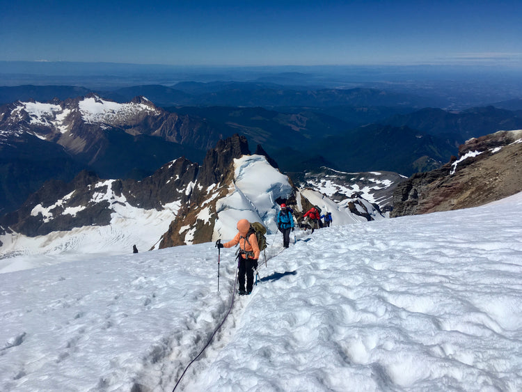 A guided trip nears the summit of Mount Baker while views of Colfax, the Twin Sisters, and the Puget Sound are below. 