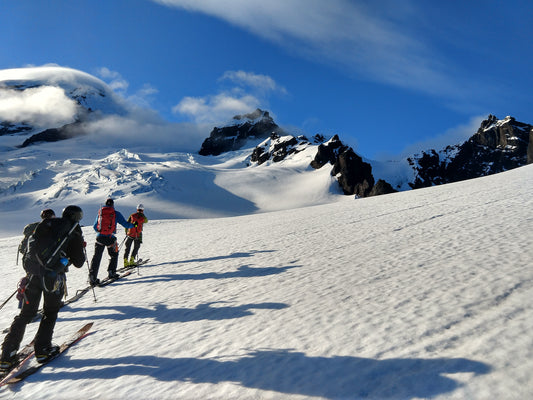 Splitboarders on Mount Baker making their way up through glaciated terrain towards the summit.