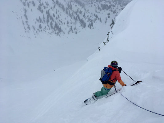 A split boarder takes a belay while sizing up steep terrain in the Mount Baker Backcountry during an advanced splitboard course.