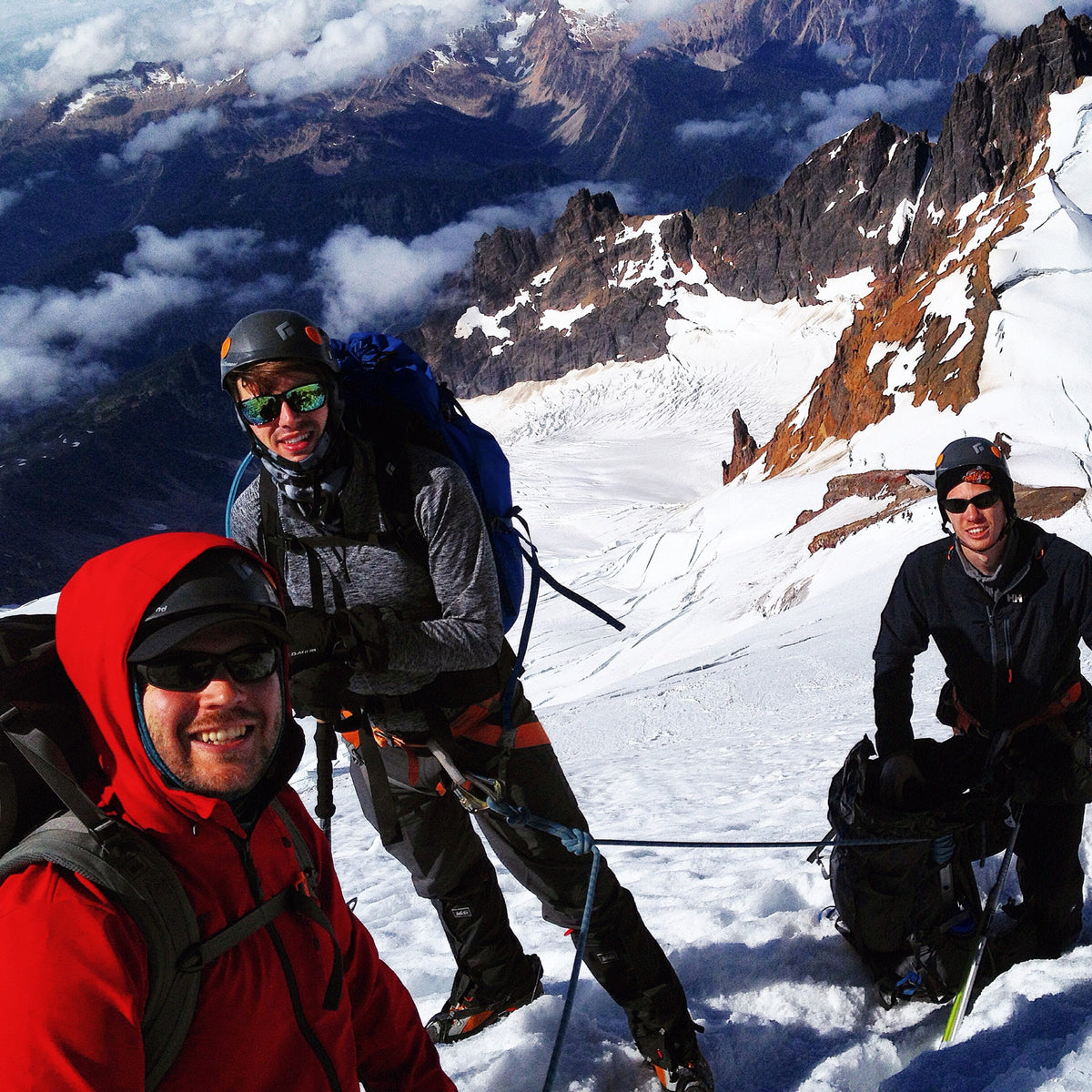 3 happy dudes with the Deming Glacier and Colfax icefall above the twin sisters on Mount Baker. 