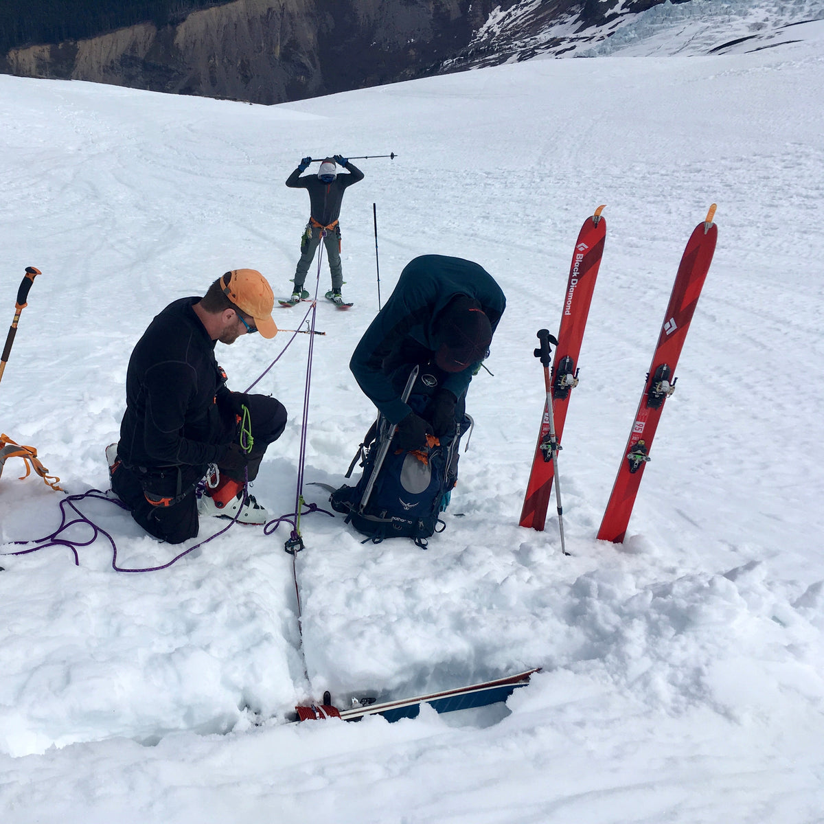 Ski mountaineers setting a snow anchor with skis planted during a 4-day ski mountaineering course at Mount Baker