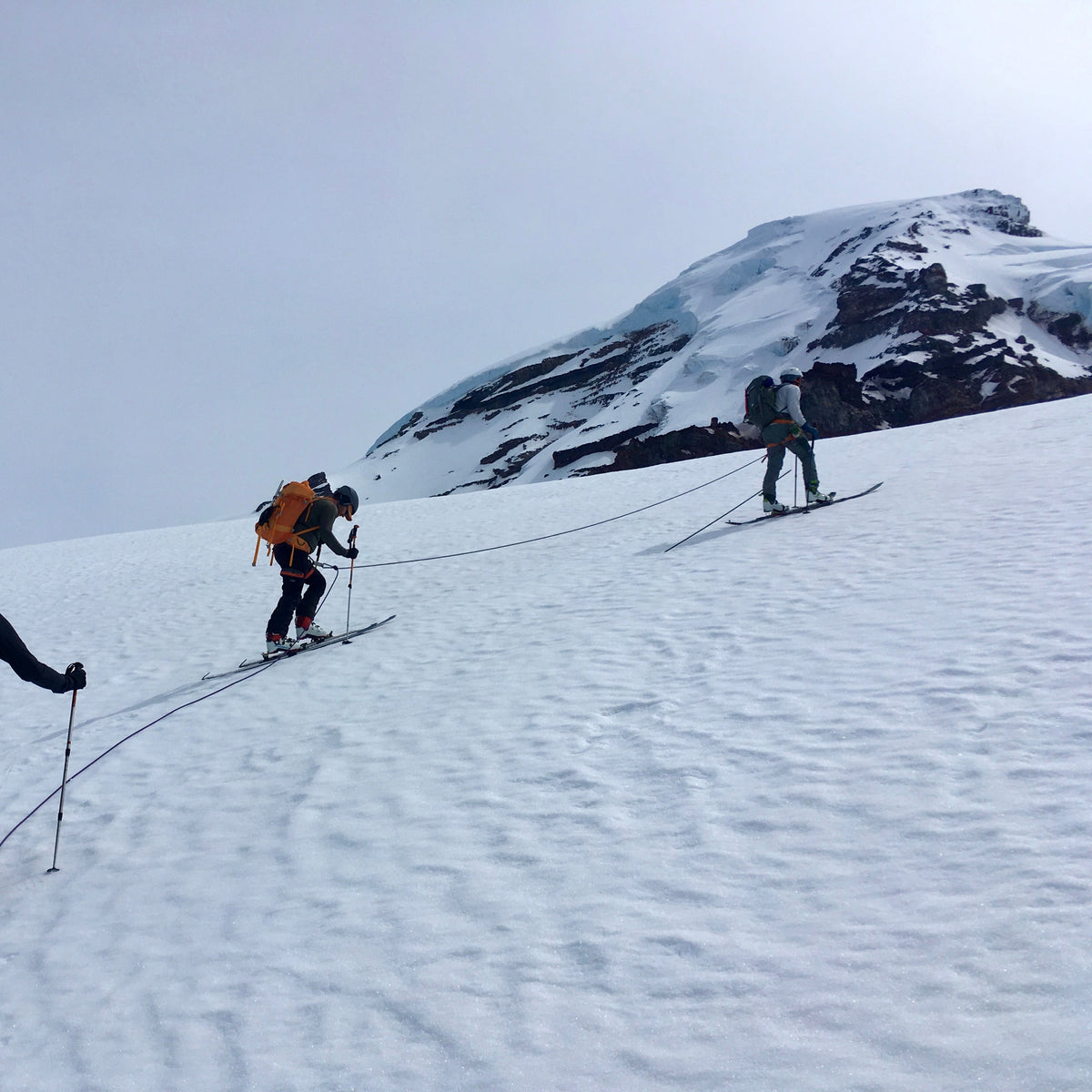 Ski tourers skinning toward Mount Baker's snowy summit dome during a 4-day ski mountaineering course