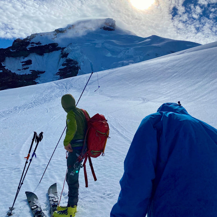 Splitboard mountaineers ascend coleman glaciers on Mount Baker using a probe to assess crevasses during a splitboard mountaineering course