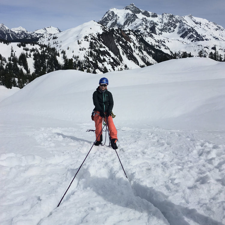 splitboarder rappels with mount shuksan at artist point during a course with guides at mount baker