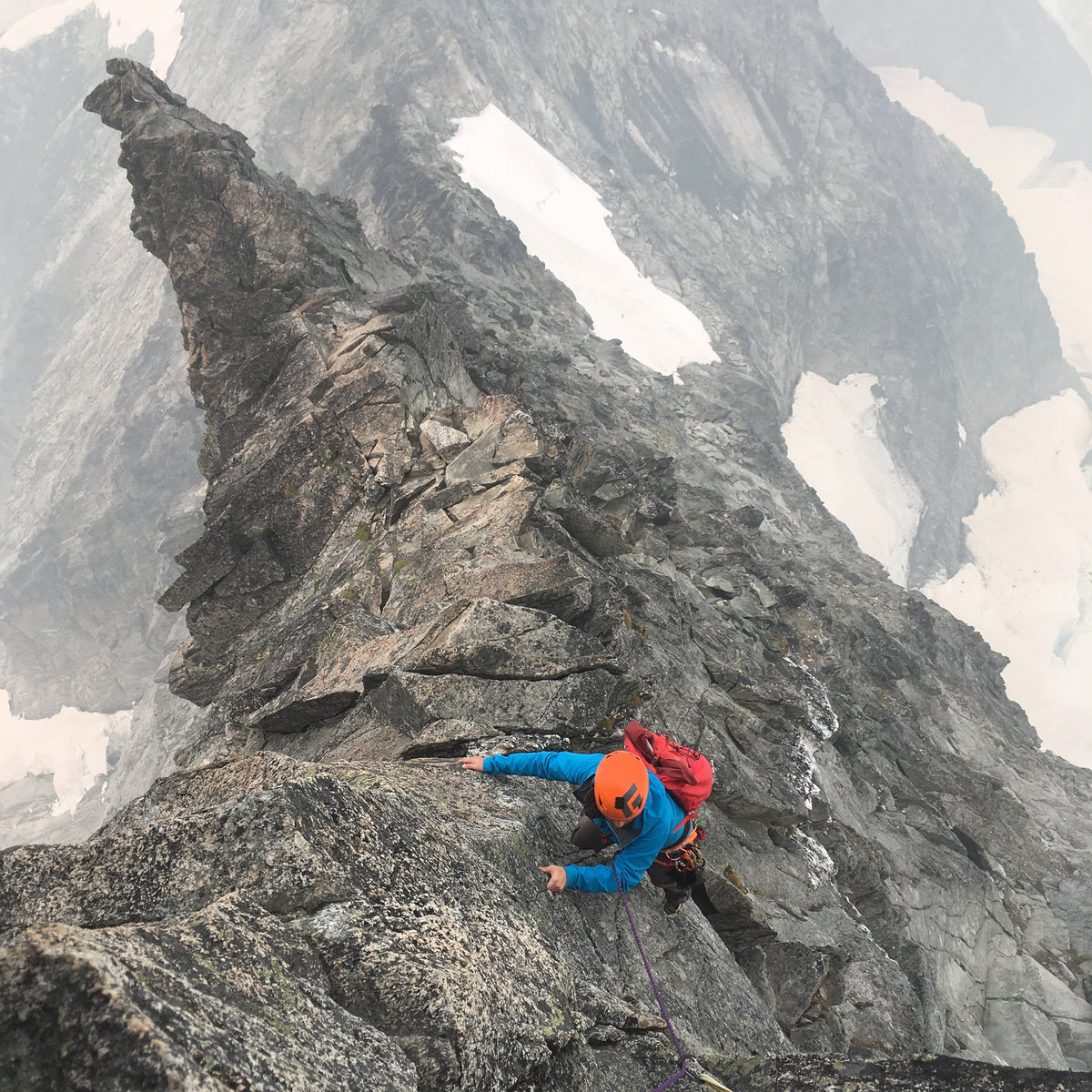 a climber high on the west ridge of forbidden peak
