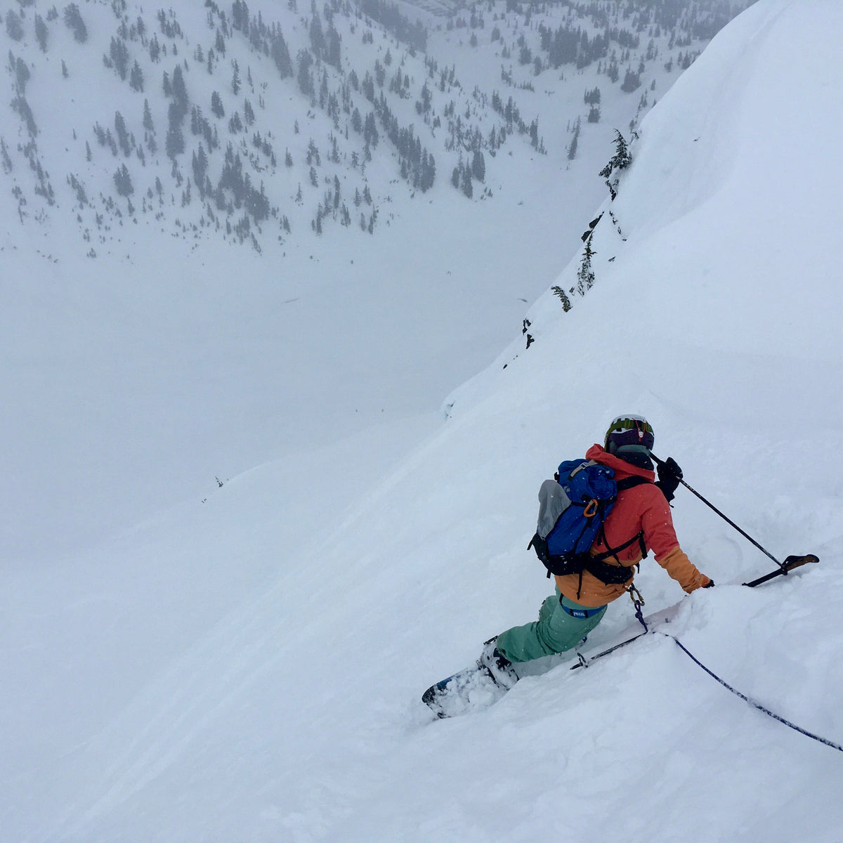 A split boarder takes a ski belay while sizing up steep terrain in the Mount Baker Backcountry during an advanced splitboard course.